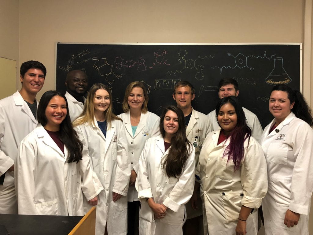 A group of scientists in front of a chalk board